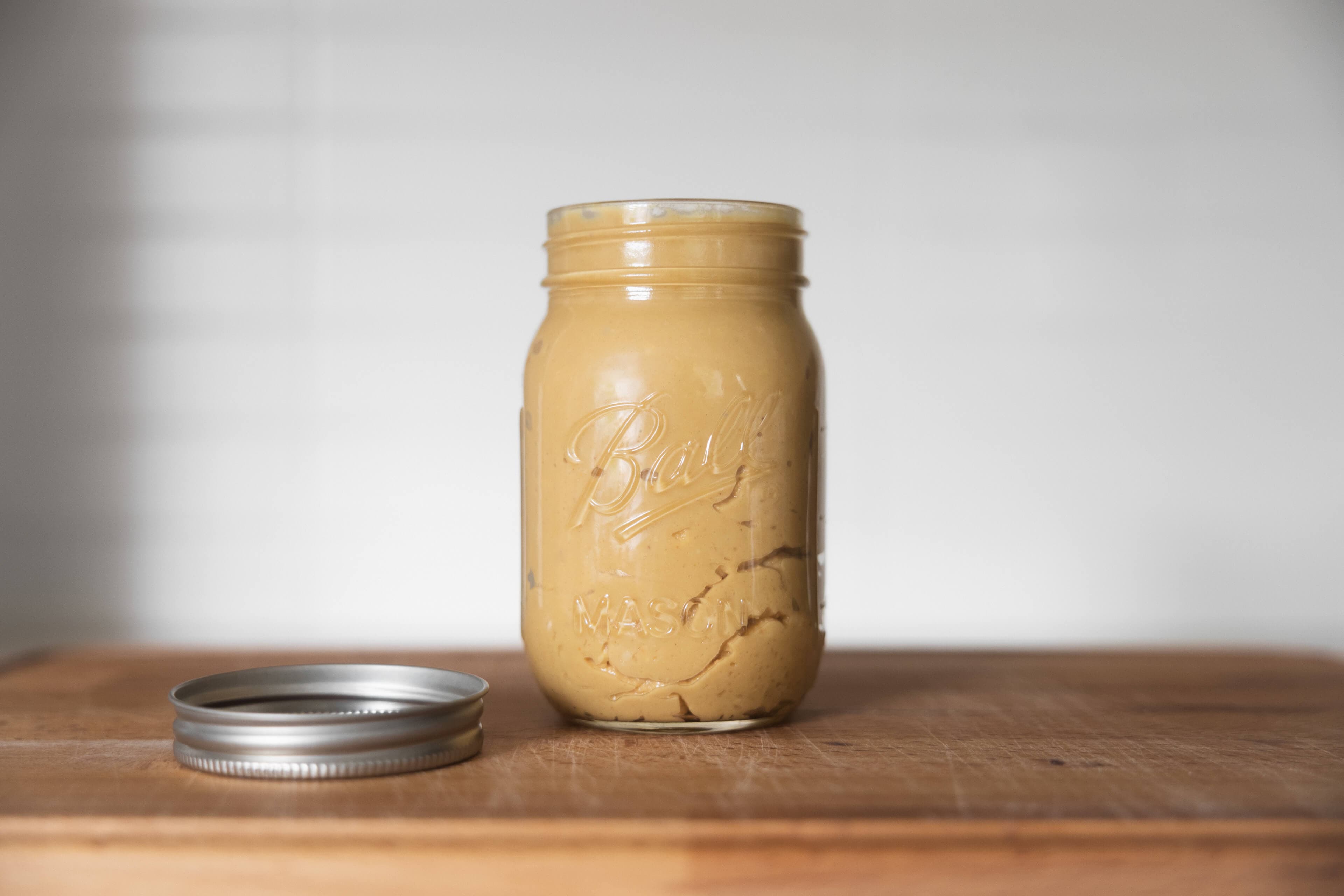 Mason jar filled with fresh homemade peanut butter.